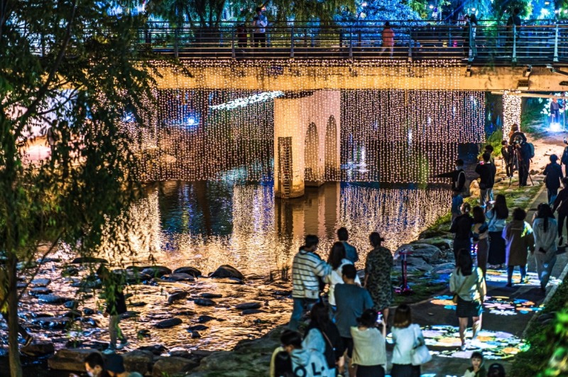 2022 수원화성 미디어아트쇼가 열린 수원천에서 시민들이 작품을 감상하며 지나고 있다.(사진=수원시)