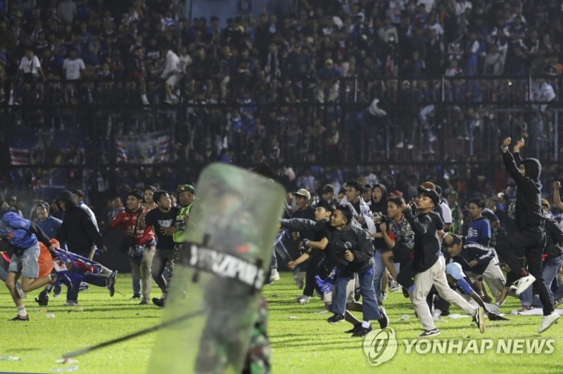 (말랑[인도네시아] AP=연합뉴스) 1일(현지시간) 밤 인도네시아 동부 자바주 말랑 리젠시에서 열린 축구 경기에서 홈팀인 '아르마 FC'가 패배하자 흥분한 팬들이 경기장으로 뛰어들고 있다. 현지 경찰은 이번 사고로 최소 129명이 사망했다고 밝혔다.