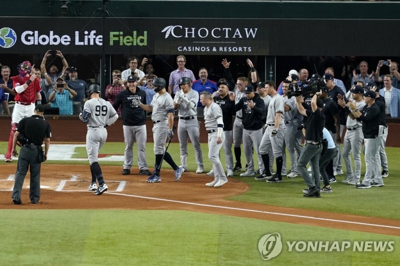 (알링턴 AP=연합뉴스) 에런 저지가 5일(한국시간) 미국 텍사스주 알링턴의 글로브라이프필드에서 열린 텍사스 레인저스와의 더블헤더 2차전 1회초 선두 타자 홈런을 치며 아메리칸리그 단일시즌 최다 홈런 기록을 경신하자, 양키스 동료들이 홈 플레이트 앞으로 나와 축하하고 있다.
