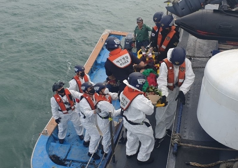 목포해경이 관사도 인근 해상에서 가슴통증 응급환자를 경비함정에 옮겨 태우고 있다 (사진제공 = 목포해양경찰서)