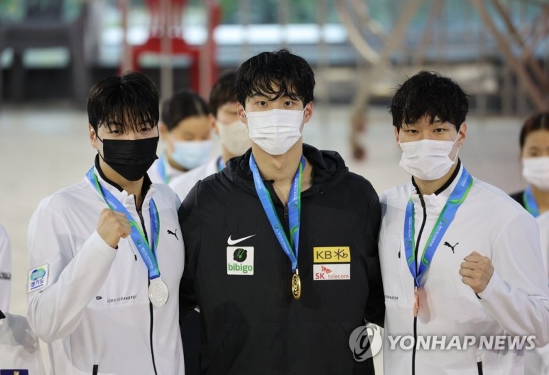 (울산=연합뉴스) 12일 오후 울산 남구 문수실내수영장에서 열린 제103회 전국체육대회 수영 남자일반부 자유형 100m에서 우승한 황선우(강원도청)가 시상식에서 금메달을 받은 뒤 기념촬영하고 있다. 왼쪽부터 2위 김진원(한국체대), 1위 황선우, 3위 이유연(한국체대).