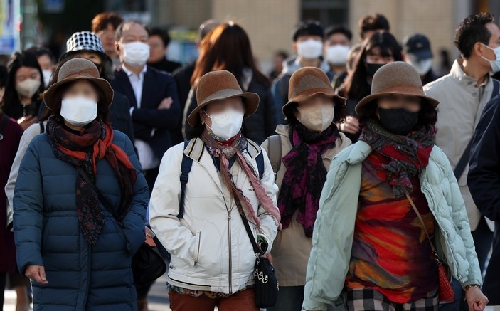 서울 아침 최저 기온이 4도까지 내려간 지난 18일 오전 서울 종로구 세종대로사거리 인근에서 시민들이 두터운 옷을 입고 이동하고 있다.