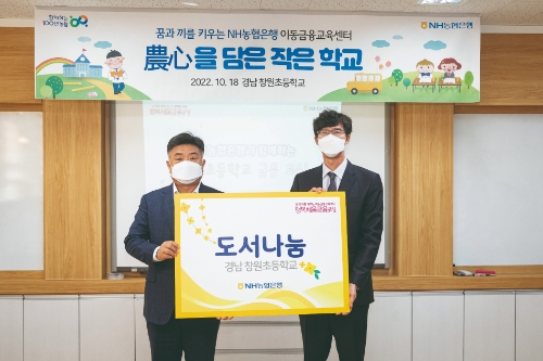 이영우 개인고객부장(사진 좌측)과 양원철 경남 창원초등학교장(사진 우측)이 도서나눔 행사에 앞서 기념촬영을 하고 있다. /사진제공=NH농협은행