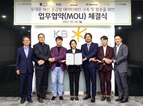 지난 24일 서울시 영등포구 KB국민은행 여의도 IT센터에서 열린 동대문 패션 공급망 데이터체인 구축 및 활용을 위한 업무협약식에서 (왼쪽부터) 윤진수 KB국민은행 테크그룹 대표, 이한수 굿티어 대표, 박재현 람다256 대표, 이연 쉐어그라운드 대표, 서원준 셀메이트 대표, 조형일 위아더 대표, 권오형 윙크스톤파트너스 대표가 기념촬영을 하고 있다. /KB국민은행