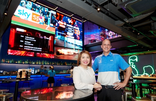 LG전자가 방콕에 오픈한 스포츠 문화공간 탑골프 메가시티에 상업용 디스플레이 솔루션을 대거 공급했다. 탑골프 내 스포츠 바에 설치된 초대형 LED 사이니지 앞에서 (왼쪽부터) LG전자 태국법인 BS 세일즈 디렉터 지라파 콩솽웡사와 탑골프 태국 운영책임자 팀 보다가 기념촬영을 하는 모습. (사진 = LG전자 제공)