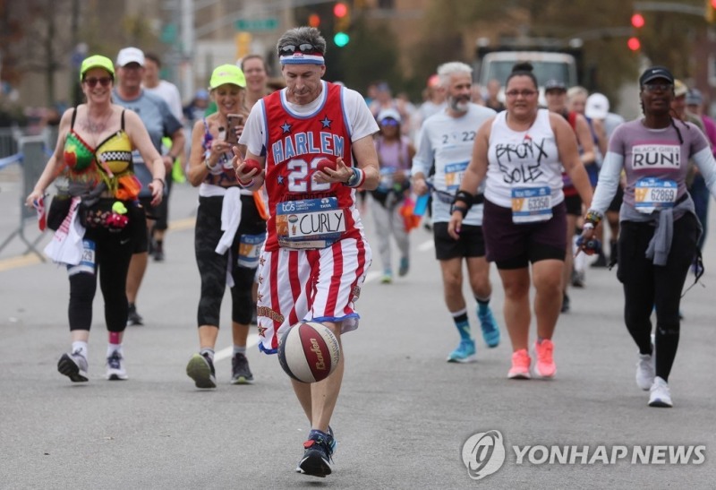 (뉴욕 로이터=연합뉴스) 농구 유니폼 차림에 공을 들고 뉴욕 마라톤에 참가한 미국 시민.