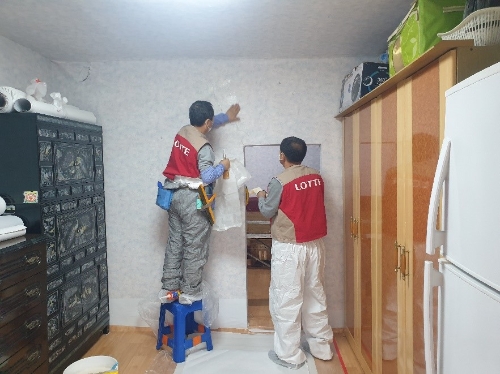 롯데건설 샤롯데 봉사단이 벽지 도배 공사를 진행하고 있다 / 사진 제공 : 롯데건설