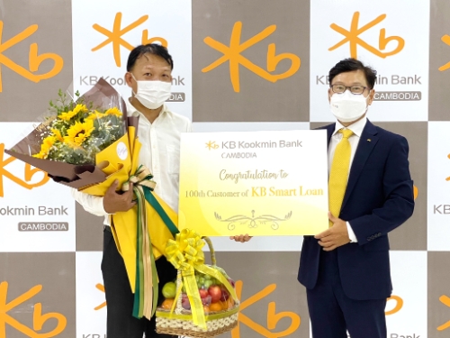 KB캄보디아은행 본점에서 열린 KB스마트론 신규고객 기념 행사에서 (오른쪽)장용재 KB캄보디아은행 법인장과 고객이 기념촬영을 하고 있다. / 사진 제공 : KB국민은행
