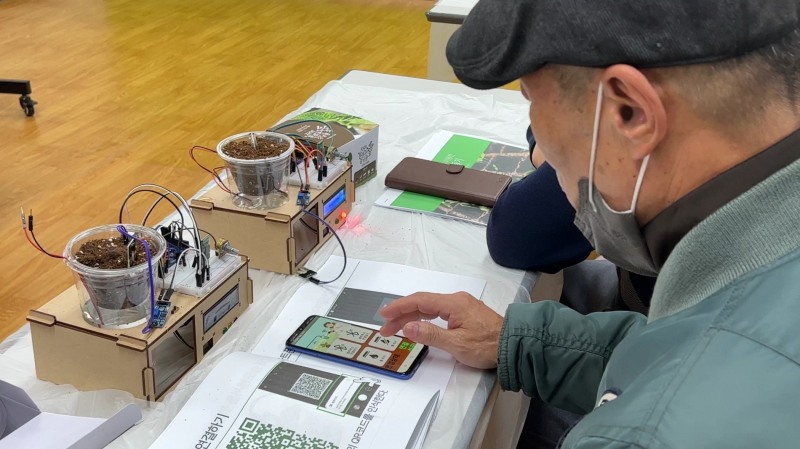 거모종합사회복지관 어르신들이 스마트팜 키트를 통해 식물키우는 법을 익히고 있다.(사진제공=에프엔제이)