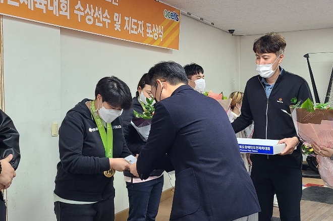 한화큐셀 장애인스포츠단이 22일 청주종합운동장 내 훈련장에서 제42회 전국장애인체육대회 수상선수 및 지도자 대상 포상식을 개최했다. 사진은 역도 종목에서 금·은·동메달 각 1개씩을 수상한 한화큐셀 김민지(왼쪽) 선수에게 한화큐셀 장애인스포츠단 임원배(오른쪽) 단장이 포상금과 격려품을 수여하고 있는 모습. (사진 = 한화솔루션 제공)