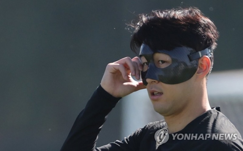(도하=연합뉴스) 축구대표팀의 손흥민이 2022 카타르 월드컵 조별리그 첫 경기 우루과이전을 하루 앞둔 23일 오전(현지시간) 카타르 도하 알에글라 훈련장에서 열린 공식훈련에서 몸을 풀던 중 마스크를 만지고 있다.