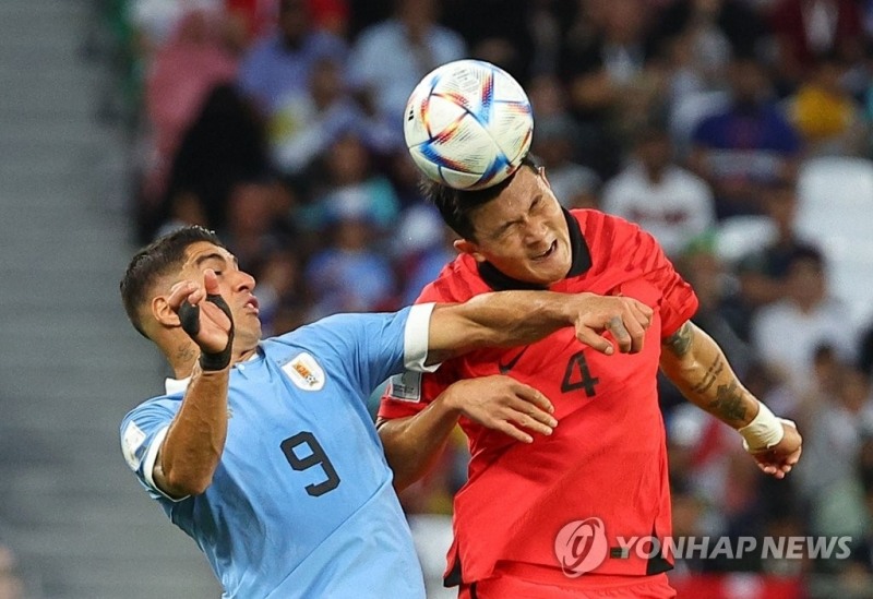 김민재(오른쪽)가 우루과이전에서 수아레스와 공중볼을 다투고 있다.