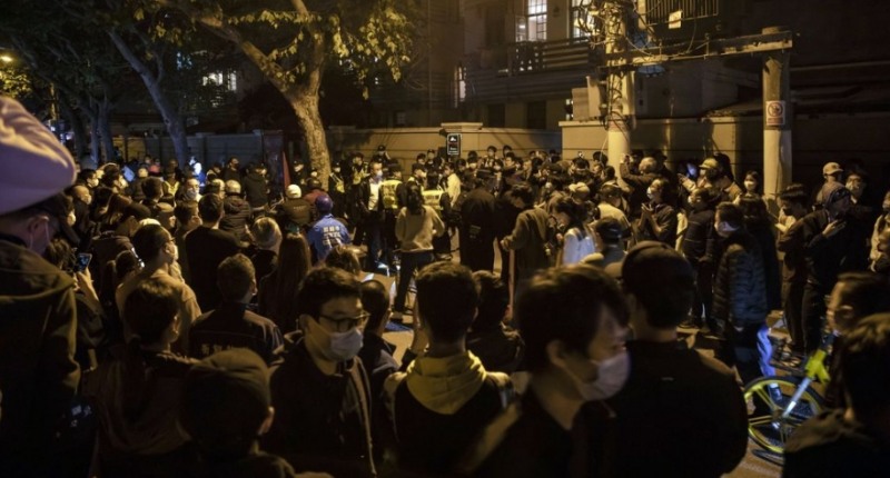 사진=블룸버그, 지난 27일 중국 상하이시 한 지역에서 일부 시민들의 시위가 발생한 가운데, 이를 방어하는 공안들을 구경꾼들이 지켜보고 있다.