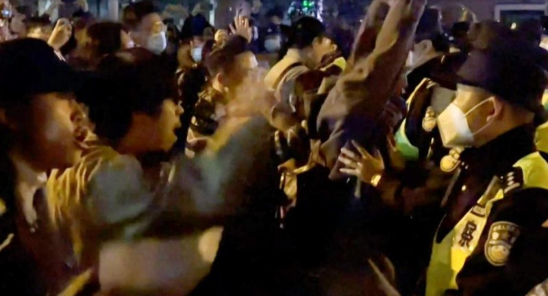 사진=AFP사진, 상하이 공안들과 대치하고 있는 일부 시위자들이 시진핑 퇴진을 요구하고 있다.