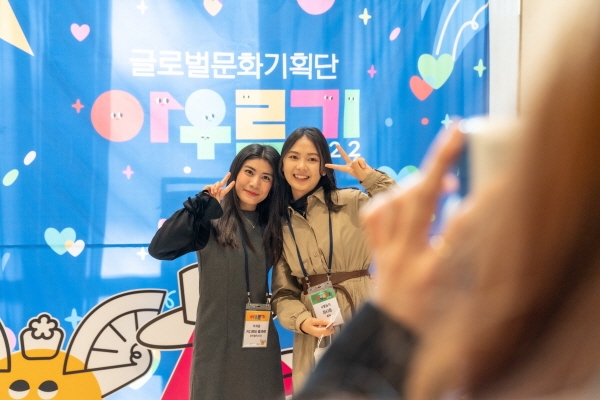 지난 11월 20일 ‘2022 아우르기 해단식’에서 부채춤 단원과 사물놀이팀 단원이 포토월 앞에서 기념촬영을 하고 있다.(사진제공=한국국제문화교류진흥원)