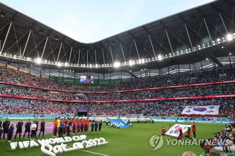 (알라이얀=연합뉴스) 24일 오후(현지시간) 카타르 알라이얀의 에듀케이션 시티 스타디움에서 열린 2022 카타르 월드컵 조별리그 H조 1차전 한국과 우루과이 경기. 한국 대표팀 선수들이 애국가를 부를 때 관중석에 대형 태극기가 펼쳐지고 있다.