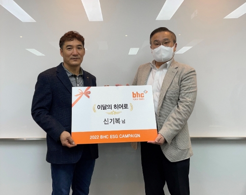 bhc그룹 SP/직영사업부 고병환 상무(우측)가 지난 28일 ‘bhc 히어로’로 선정된 신기복 씨(좌측)를 만나 상장과 치킨 상품권을 전했다. / 사진 제공 = bhc그룹