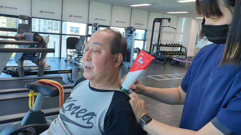 김인식 감독이 '닥터 바로겔'로 통증이 있는 어깨부위에 마사지를 하고 있다.