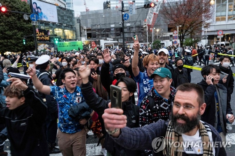 (도쿄 AFP=연합뉴스) 일본 축구 국가대표팀이 2022 카타르 월드컵 조별리그 E조 스페인과의 경기에서 승리한 2일, 도쿄에서 일본 축구를 응원하는 팬들이 기뻐하고 있다. 이날 스페인에 2-1 역전승을 거둔 일본은 E조 1위로 조별리그를 마감, 2018 러시아 월드컵에 이어 두 대회 연속 16강 진출에 성공했다.