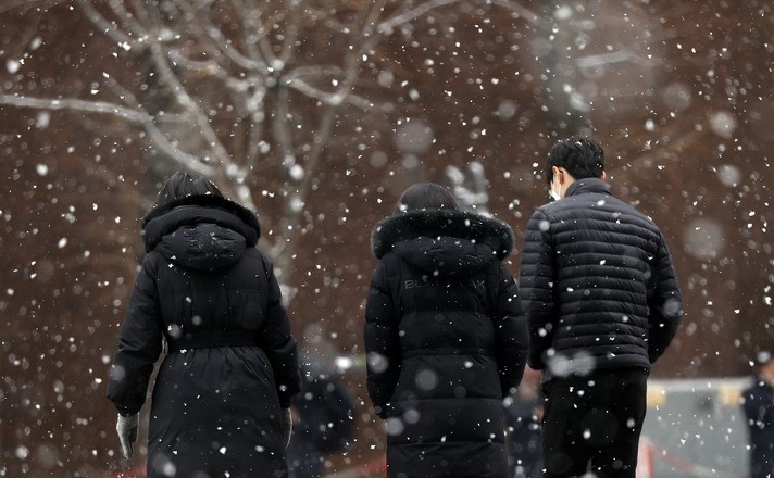 전국 대부분 지역에 눈이 내린 지난 1월19일 서울 중구 한 거리에서 시민들이 눈을 맞으며 발걸음을 옮기고 있다.