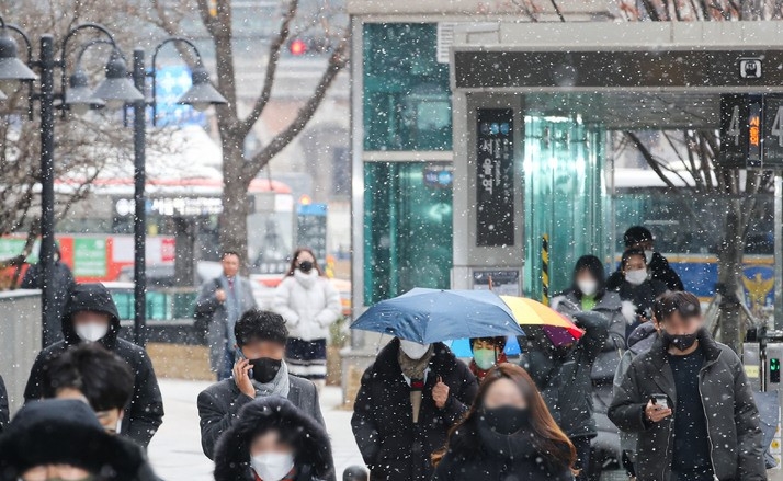 눈이 내리고 있는 지난 6일 오전 서울 중구 서울역 인근에서 시민들이 눈을 맞으며 출근하고 있다.