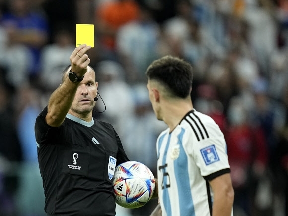 안토니오 마테우 주심이 9일 카타르 루사일의 루사일 스타디움에서 열린 네덜란드와 아르헨티나의 월드컵 8강전에서 아르헨티나의 리산드로 마르티네스에게 옐로카드를 보여주고 있다. [AP=연합뉴스]