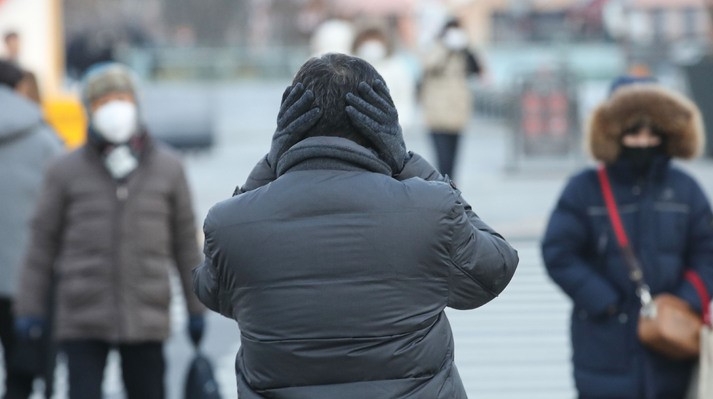 강력한 한파가 찾아온 지난 14일 오전 서울 종로구 광화문네거리에서 직장인이 추운날씨에 양손으로 귀를 덮고 출근하고 있다.