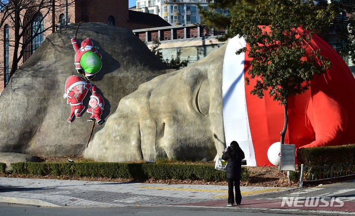 지난 22일 오후 대구 달서구 진천동 선사유적공원 내 거대 원시인 석상에 산타 모자와 산타 가족 조형물이 설치돼 있다.