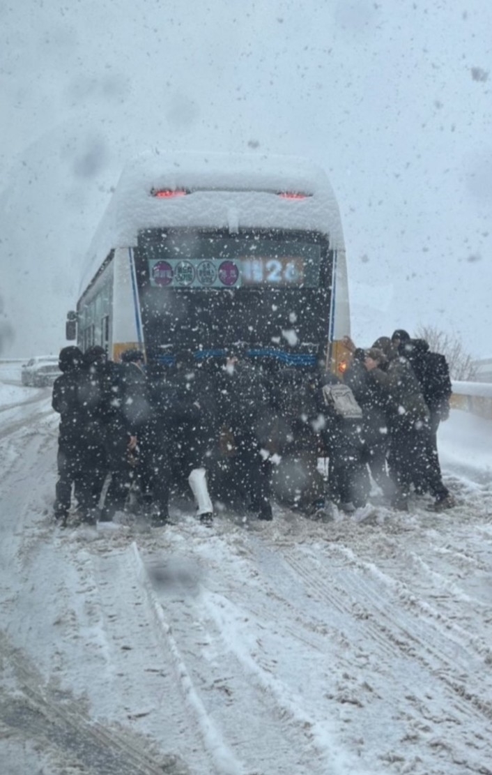 광주에 대설경보가 내려진 23일 북구 운암고가교에서 승객으로 추정되는 시민들이 버스를 밀고 있다. (사진=독자제공)