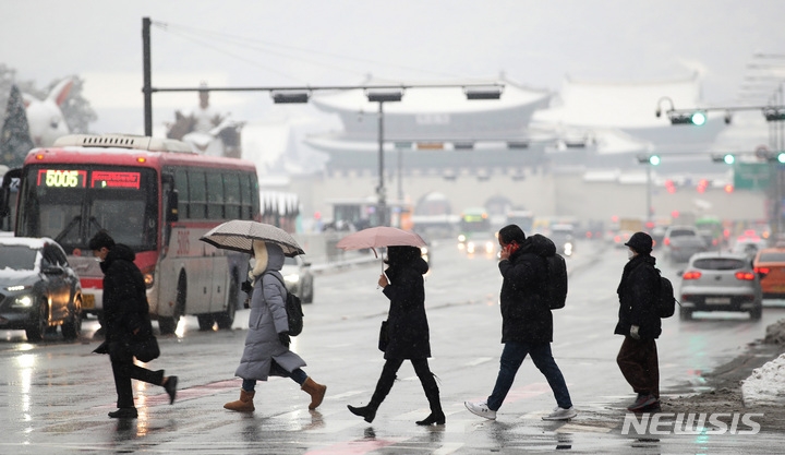 서울·경기 등 수도권을 중심으로 많은 눈이 내린 지난 21일 서울 광화문네거리 일대에서 시민들이  출근하고 있다.