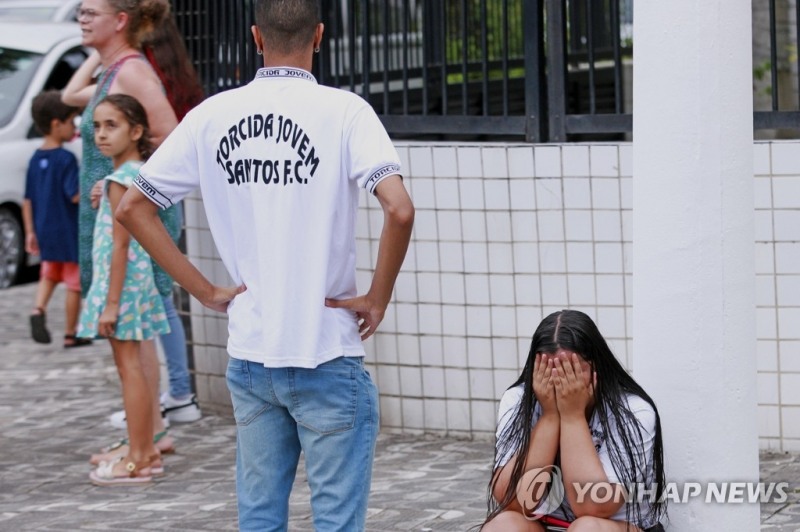(산투스 AP=연합뉴스) 29일(현지시간) 브라질 산투스 빌라 베우미루 축구장 밖에서 한 시민이 펠레 별세 소식에 얼굴을 감싸고 울음을 터트리고 있다. 펠레는 1956년부터 1974년까지 브라질 산투스에서 뛰며 공식전 660경기에서 643골을 넣었다.