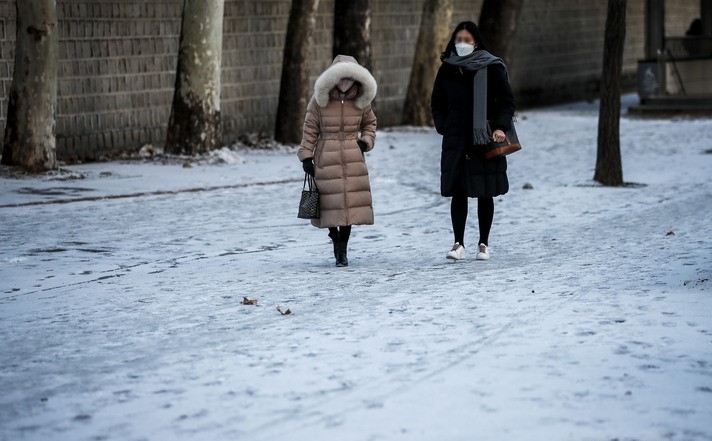 추운 날씨가 이어지고 있는 지난 28일 오전 서울 중구 시청역 인근에서 시민들이 눈 내린 길을 걷고 있다.