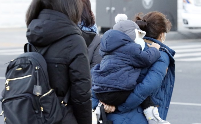 서울 아침 기온이 영하 6도를 기록하며 추운 날씨를 보인 지난 2일 서울 광화문광장에서 한 유아가 어머니의 등에 업혀 있다.