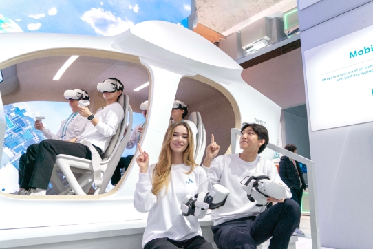 SKT 모델들이 SK전시관에서 사피온 반도체가 기체 운항을 지원하고, 신재생 에너지 가상 발전소가 전력을 공급하는 도심항공교통(UAM) 기술을 소개하는 모습