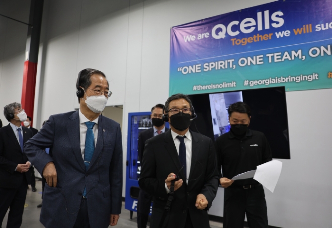 한덕수 국무총리가 지난해 10월 16일 미국 조지아주 한화큐셀 태양광 패널공장을 방문해 운영현황을 보고 받은 후 생산라인을 둘러보며 설명을 듣고 있다. / 연합뉴스