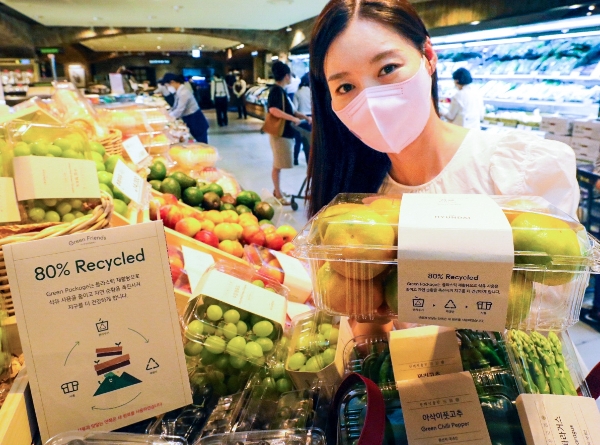 현대백화점 압구정본점 지하 1층 식품관에서 직원이 재활용 PET를 활용해 제작한 농산물 용기를 소개하는 모습 / 사진 제공 : 현대L&C