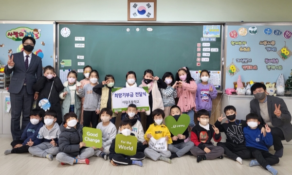4일(수), 굿네이버스 경기2본부(본부장 김영배)는 아람초등학교 1학년으로부터 바자회 수익금 162,000원을 전달받았다. 사진은 1학년 1반 아동들과 후원금 전달식을 진행하는 모습. 왼쪽부터 고경민 아람초등학교장, 1학년 1반 아동 전원, 김영배 경기2본부장. / 사진 제공 : 굿네이버스