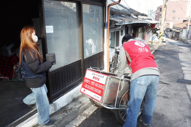 롯데건설은 설 명절을 앞두고 지난 11일과 16일 이틀에 걸쳐 서울연탄은행과 부산연탄은행에 각 4만장씩 총 8만장의 연탄을 기부했다고 17일 밝혔다. 사진은 롯데건설 직원과 서울연탄은행 소속 사회복지사가 서울 104마을에서 _사랑의 연탄나눔_에 참여하고 있는 모습. (사진 = 롯데건설 제공)
