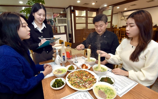 서울시 양천구 목동의 ‘한옥안동국시’ 사장님이 골목경제 부활 프로젝트에 참여한 숙명여대 ‘같이가게’ 팀원들에게 빅데이터 상권분석 컨설팅을 받고 있다. / 사진 제공 : KT