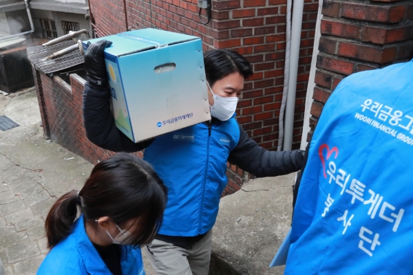 우리금융미래재단 직원들이 새해를 맞아 독거어르신에게 ‘우리 새해 복꾸러미’를 전달했다. / 사진 제공 : 우리금융