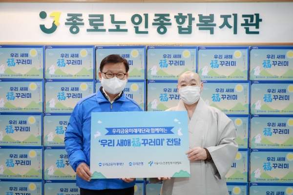 우리은행이 20일 종로노인종합복지관에 '우리 새해 복 꾸러미' 를 전달했다. 이원덕 우리은행장과 정관 관장이 기념사진을 촬영하고 있다. / 사진 제공 : 우리은행