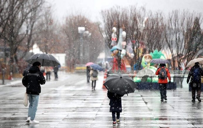 눈이 내린 지난 15일 서울 종로구 광화문광장에서 우산을 쓴 시민들이 길을 걷고 있다.