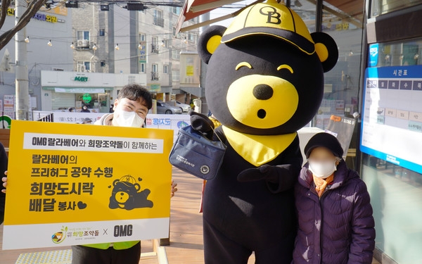 오비맥주 ‘오엠쥐(OMG)’ 랄라베어와 희망조약돌이 독거어르신에게 도시락을 전달하고 있다. / 사진 제공 : 희망조약돌