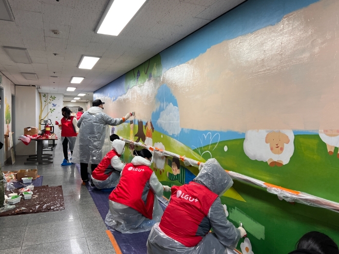 LG유플러스가 실내 마스크 착용 중단을 시작으로 본격화된 위드코로나 시대를 맞아 임직원 직접 참여하는 ‘체험형 봉사활동’을 확대 시행한다고 1일 밝혔다. 사진은 지난해 연말 '삼동소년촌'에서 진행한 벽화 그리기 봉사활동 현장 모습. (사진 = LG유플러스 제공)