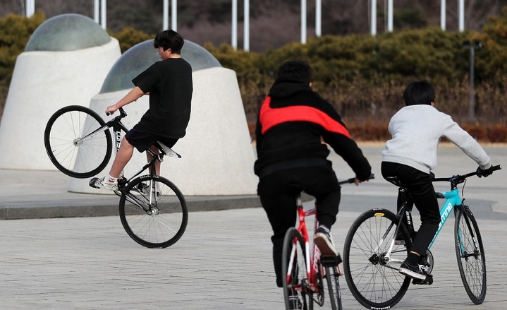 오전과 비교해 비교적 포근한 날씨를 보인 지난달 29일 오후 서울 송파구 올림픽공원에서 한 시민이 반팔, 반바지를 입고 자전거를 타고 있다.