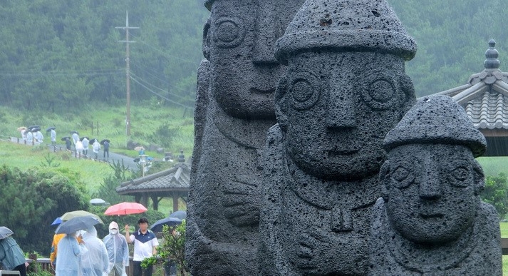 제주 서귀포시 대정읍 송악산에 우산을 쓴 관광객들이 걸어가고 있다.