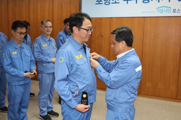 포스코 포항 본사에서 김학동 부회장이 누계 3,000시간 이상을 달성한 포항 지역 직원 14명을 대상으로 인증패와 회사 금배지를 수여하고 격려했다. 김학동 부회장 포항제철소 제선부 박희수 과장에게 금배지를 수여하고 있다. / 사진 제공 : 포스코