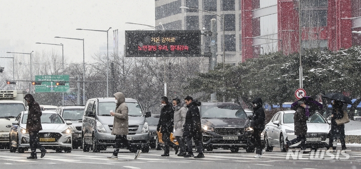 서울 지역에 많은 눈이 내린 지난달 26일 오후 서울 여의도 인근에서 시민들이 분주히 이동하고 있다.