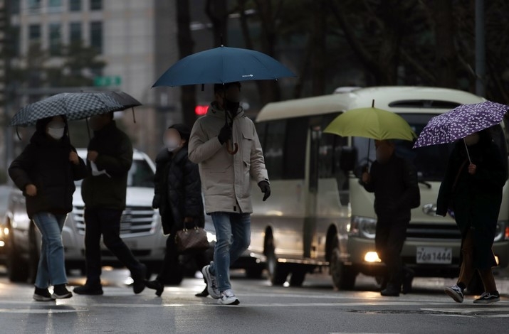 서울지역에 비가 내린 지난 10일 서울시청 인근 도로에서 우산을 쓴 직장인들이 출근하고 있다.