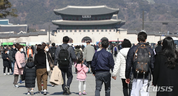 낮 최고기온 11도로 포근한 날씨를 보인 지난달 27일 서울 광화문 광장에서 시민들이 두꺼운 외투를 벗어 들고 걸어가고 있다.